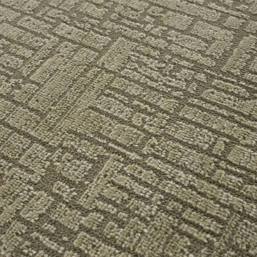 Close-up of the Leanna Green Washable Area Rug. The rug has a textured, geometric pattern in shades of gray and green. Texture