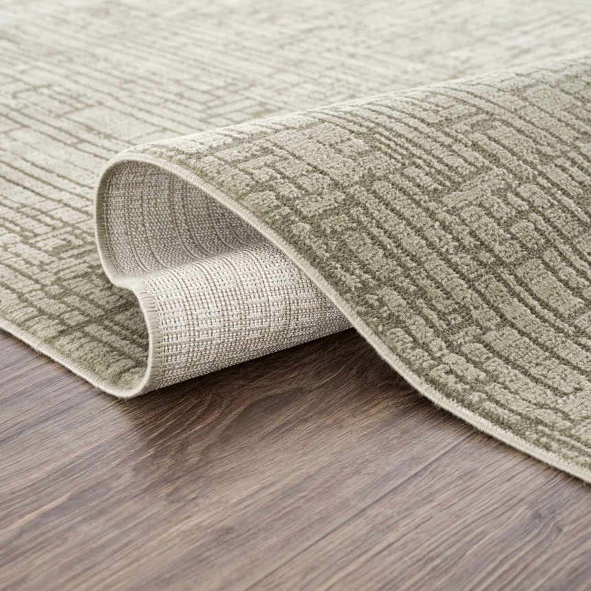 Close-up of the Leanna Green Washable Area Rug showing its gray-green color and textured, solid pattern. Fold