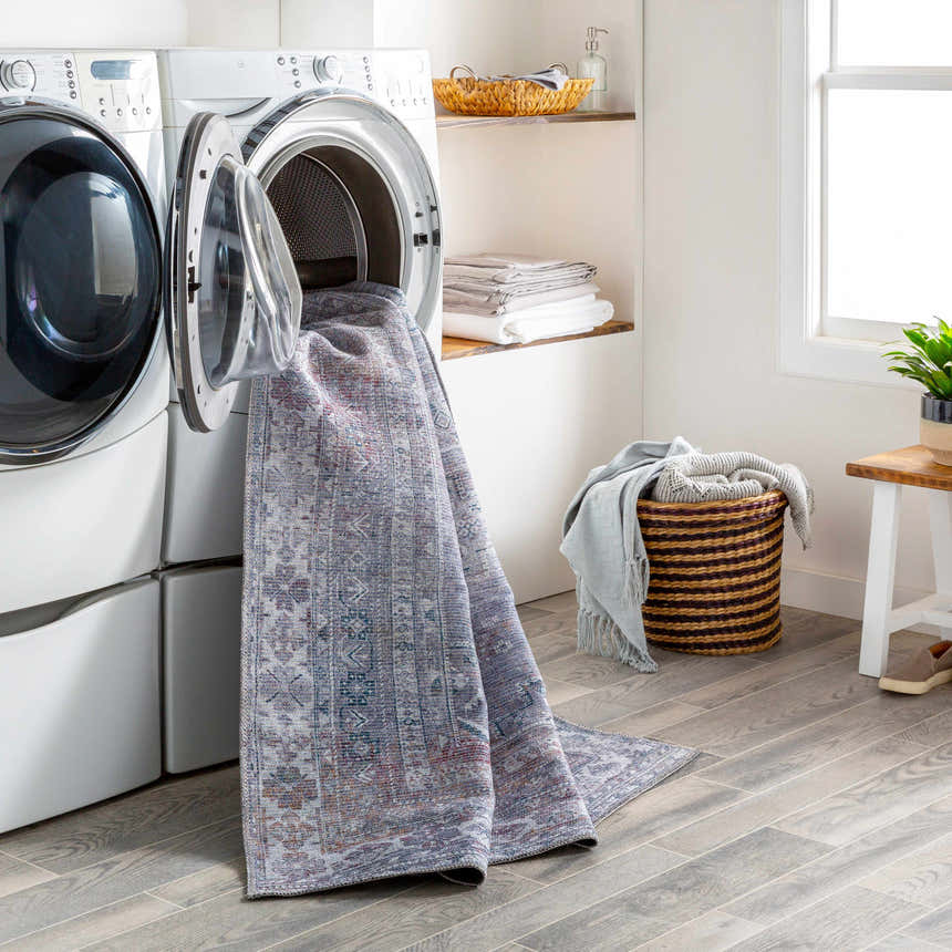 Laundry room with Livabliss Colin rug in a washing machine, showcasing its washable feature. Farmhouse style with gray wood floors. Washing-Machine