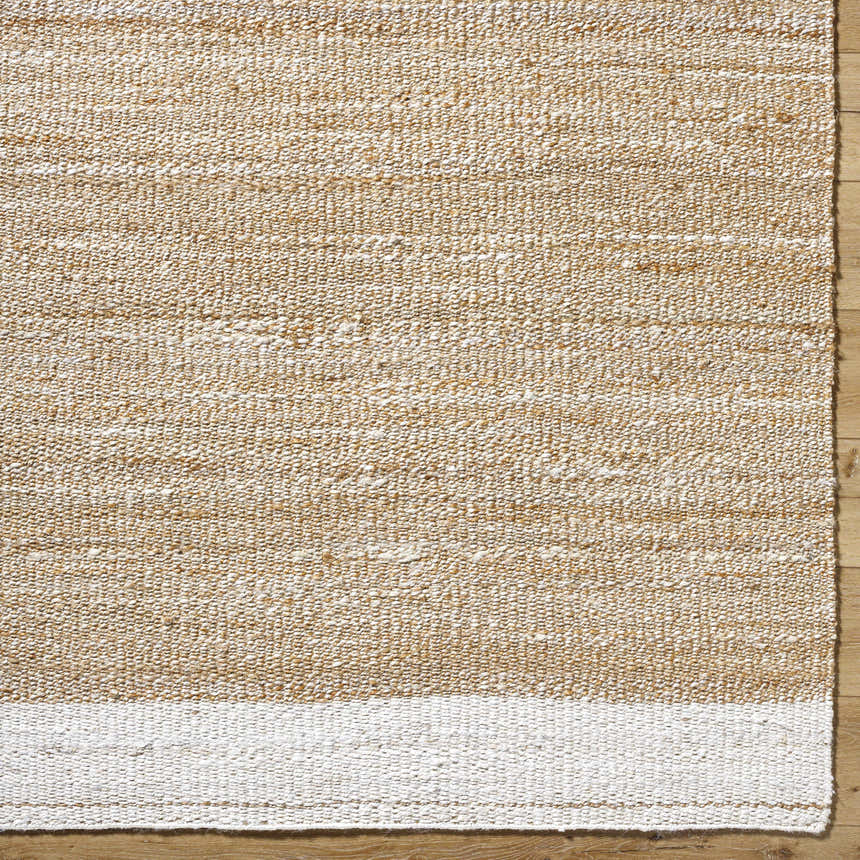 Close-up of the Aderyn Jute Area Rug showing the camel and pearl hand-woven texture and jute material. Corner