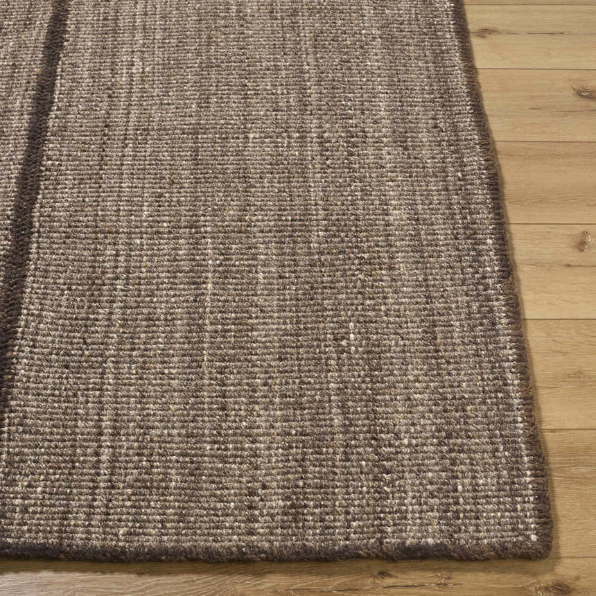 Close-up of the hand woven texture of the Lisua Global Modern Wool Area Rug in neutral brown tones on wood floor. Front