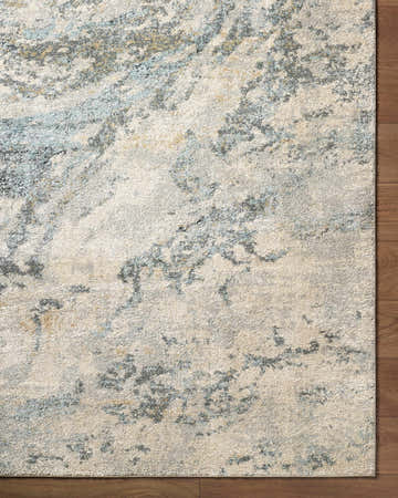 Close up of the Aliane Thick Luxe Area Rug showing beige, gray, teal, and light blue abstract pattern. Corner