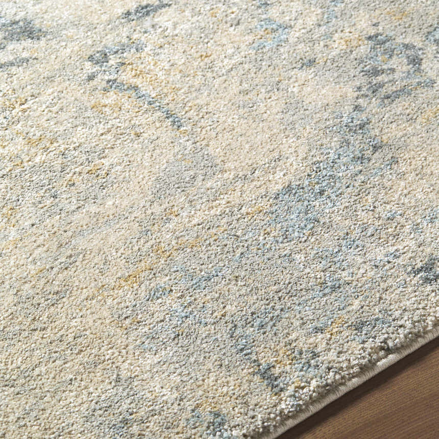 Close-up of the Aliane Thick Luxe Area Rug. Beige, gray, and pale blue abstract pattern. Soft, textured polypropylene rug. Texture