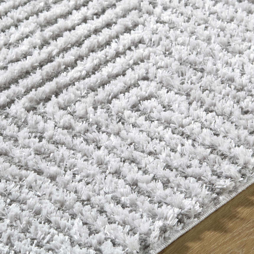 Close-up of the Ashlyn Light Slate Area Rug. Gray and light slate shag rug with a textured, machine-woven design. Texture