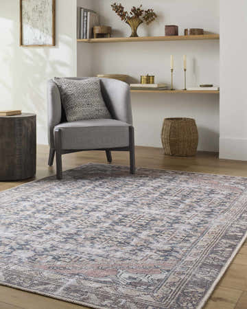 Living room scene with a gray chair on the beige, black, and blue Ameera Washable Area Rug. Roomscene-Rectangle