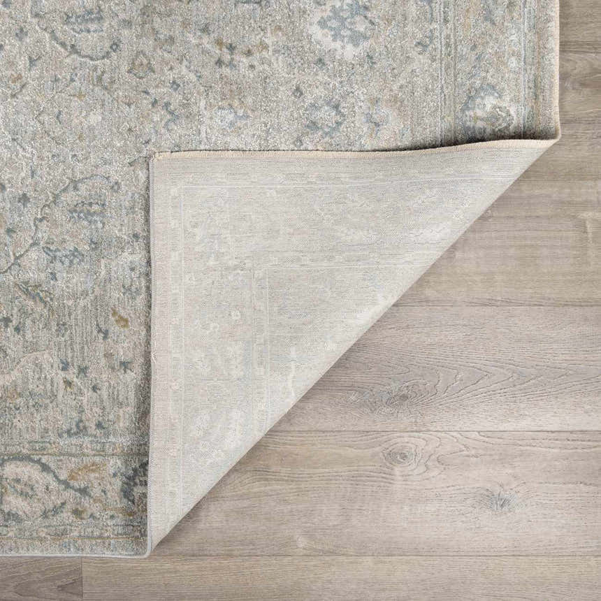 Close-up of the Glengarry Thick Luxe Boutique Rug showing its dusty sage, beige, and gray vintage-style pattern and backing. Fold
