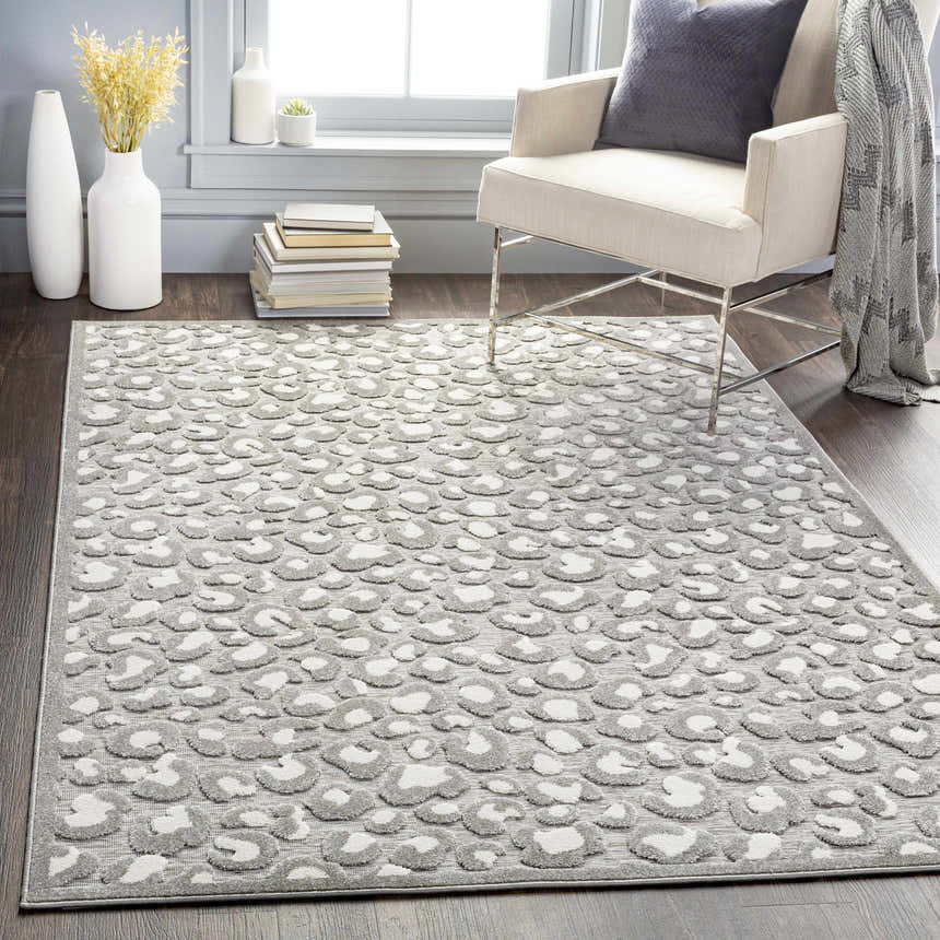 Living room scene with a Greensborough Performance Rug, featuring a gray animal print, placed under a chair. Roomscene-Rectangle