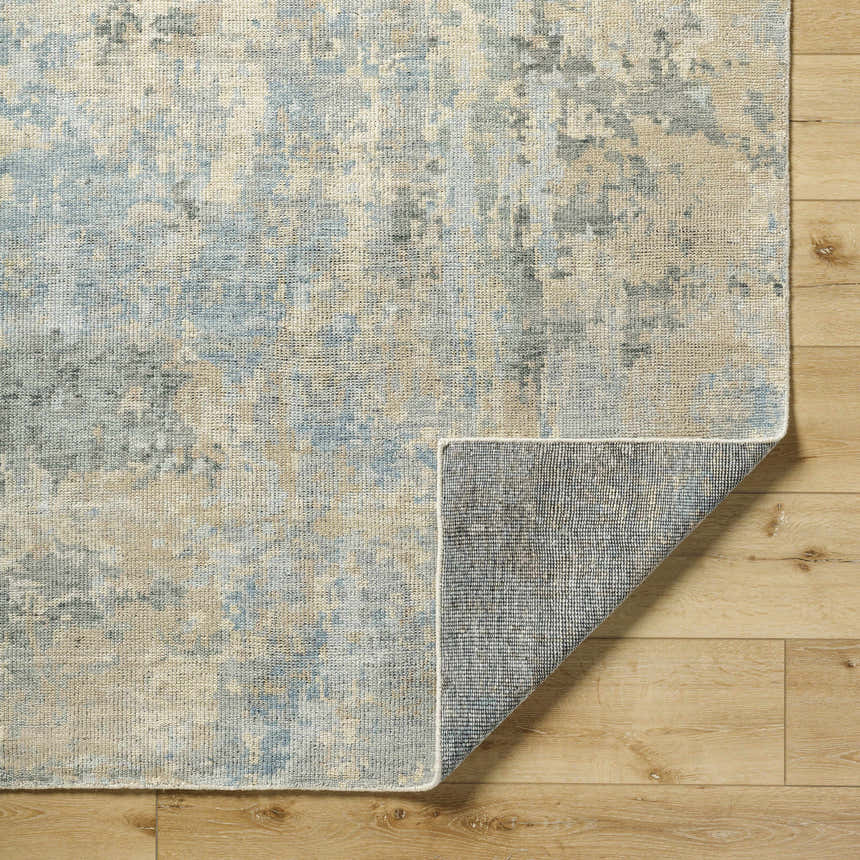 Close-up of Greenhills Handmade Wool Area Rug showing beige, blue, and gray contemporary pattern and hand-knotted texture. Fold
