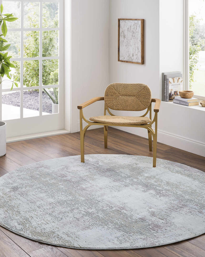 Light, airy room with a round Hanne Thick Luxe Rug in gray tones and a woven chair. Roomscene-Round