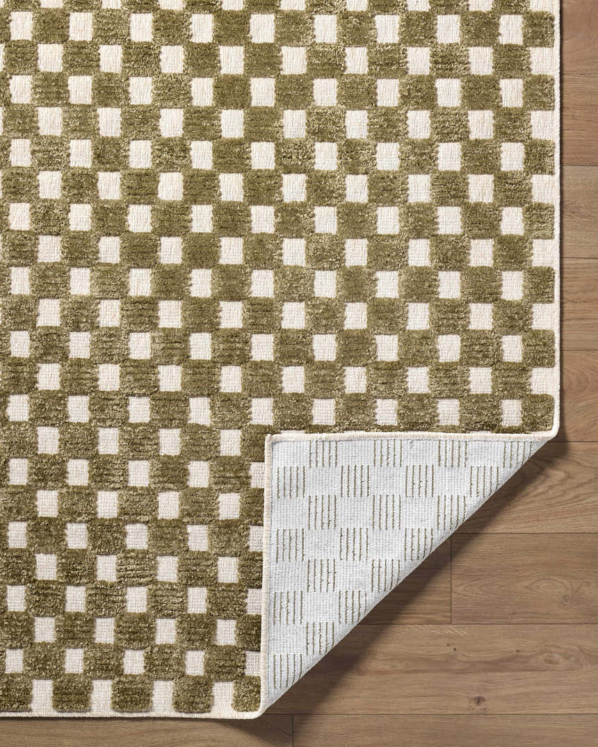 Close-up of the Anthea Olive Washable Area Rug, featuring a contemporary olive and white checkered pattern. Machine woven texture. Fold