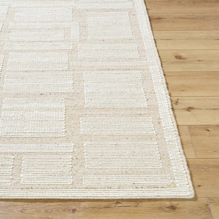 Close-up of the hand-woven Alayka Area Rug. Beige and light beige wool rug with a contemporary geometric pattern. Front