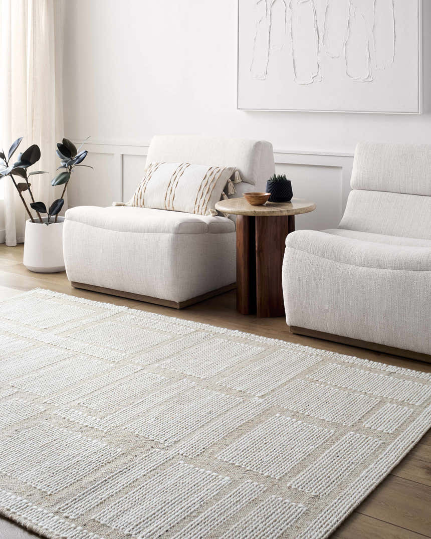 Living room scene with beige Alayka Area Rug, light neutral furniture, wood accents, and minimalist artwork. Roomscene-Rectangle