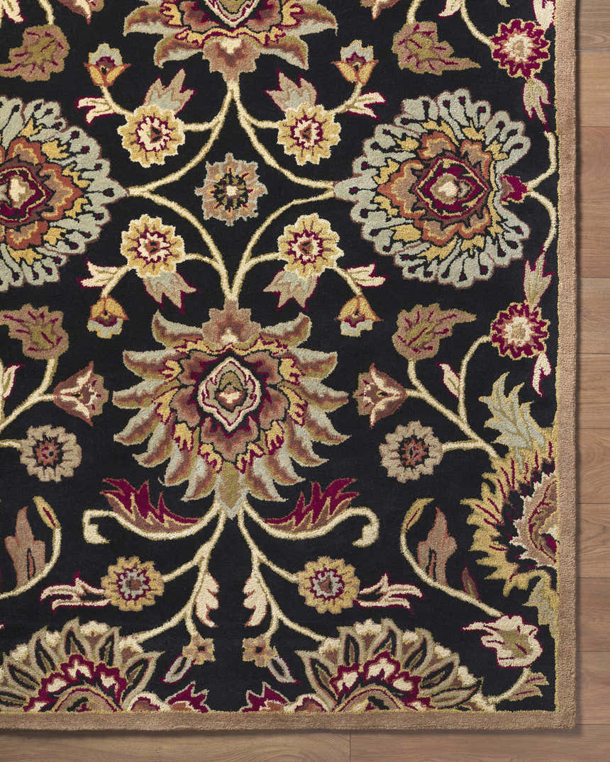 Close-up of the Conesus 1053 rug. Black wool rug with a traditional floral pattern in brown, red, mustard, and sage. Hand-tufted. Corner