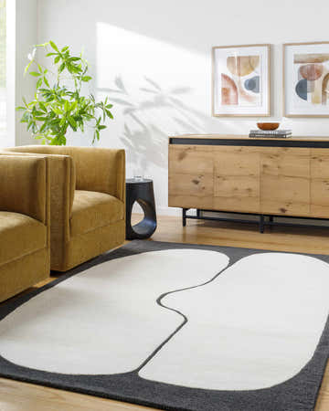 Living room scene with a contemporary Albane Area Rug. The rug is white with a gray border, styled with mustard chairs and a wood cabinet. Roomscene-Rectangle