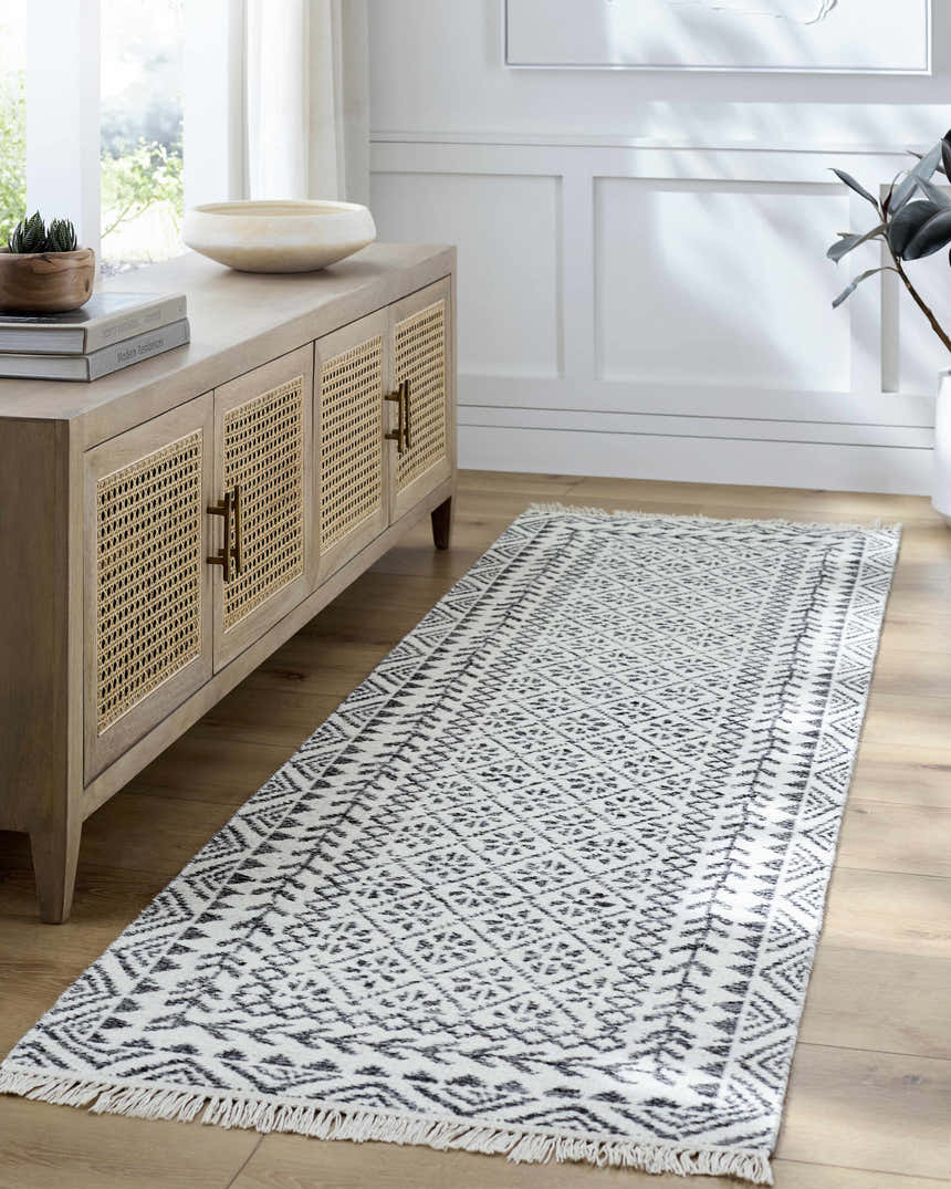 Hallway scene with a gray and white geometric Hulda Area Rug runner, light wood floors, and a matching console table. Roomscene-Runner