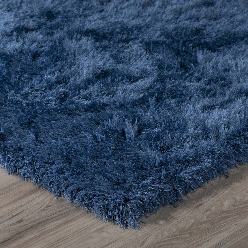 Close-up of the plush, navy blue Dalyn Impact IA100 shag rug with a soft, textured pile on wood floor.
