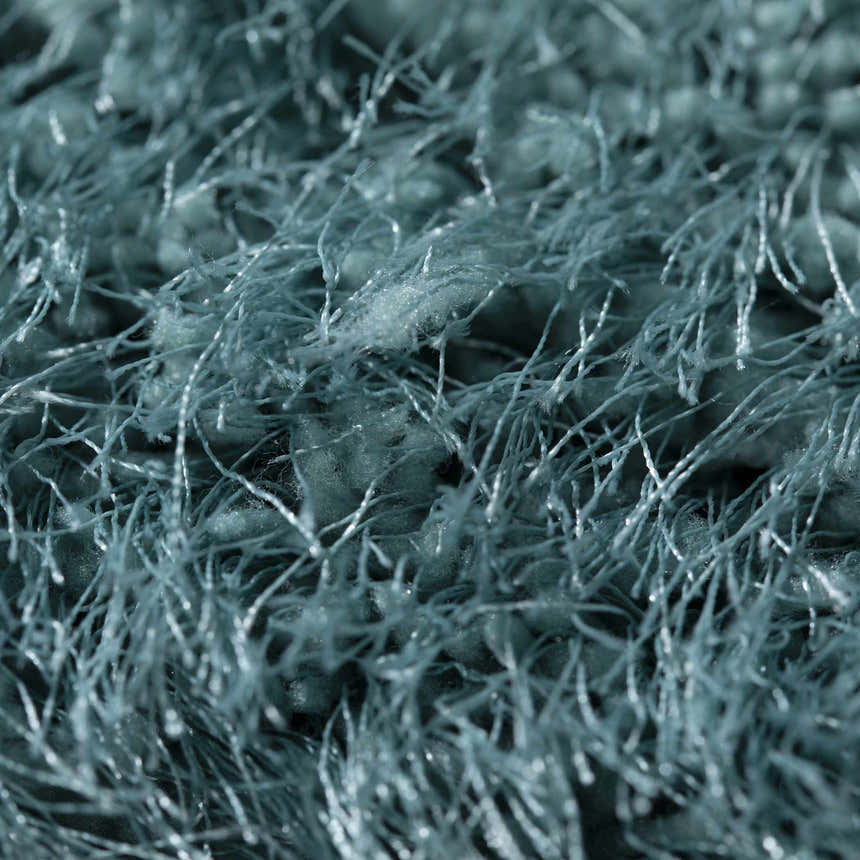 Close-up of the teal Dalyn Impact IA100 rug showing its shag texture and hand-tufted construction.