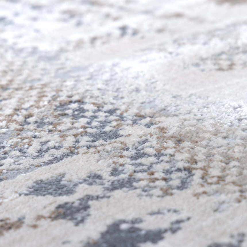 Close-up of the Ironwood Textured Luxe Rug. Charcoal, gray, light gray, medium brown, and taupe abstract pattern. Soft texture. Texture