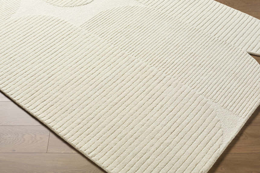 Close up of the Jgadve Ivory rug showing its hand tufted wool texture and abstract linear design. Corner