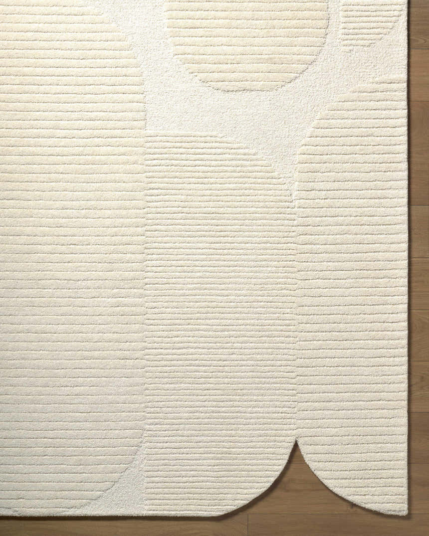 Close up of the ivory Jgadve rug. Hand tufted wool rug with abstract circle design and horizontal lines. Corner