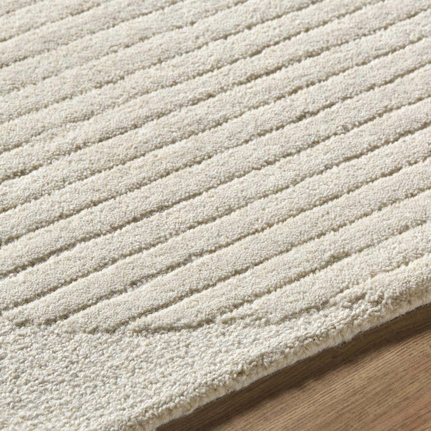 Close-up of the textured Jgadve Ivory Abstract Area Rug. Hand-tufted wool rug with a subtle striped pattern. Texture