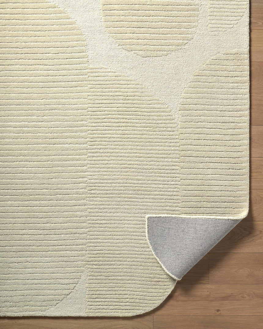 Close-up of the Ecru Abstract Modern Hand Tufted Wool Area Rug showing the textured ecru, ivory, and sandstone circle pattern. Fold