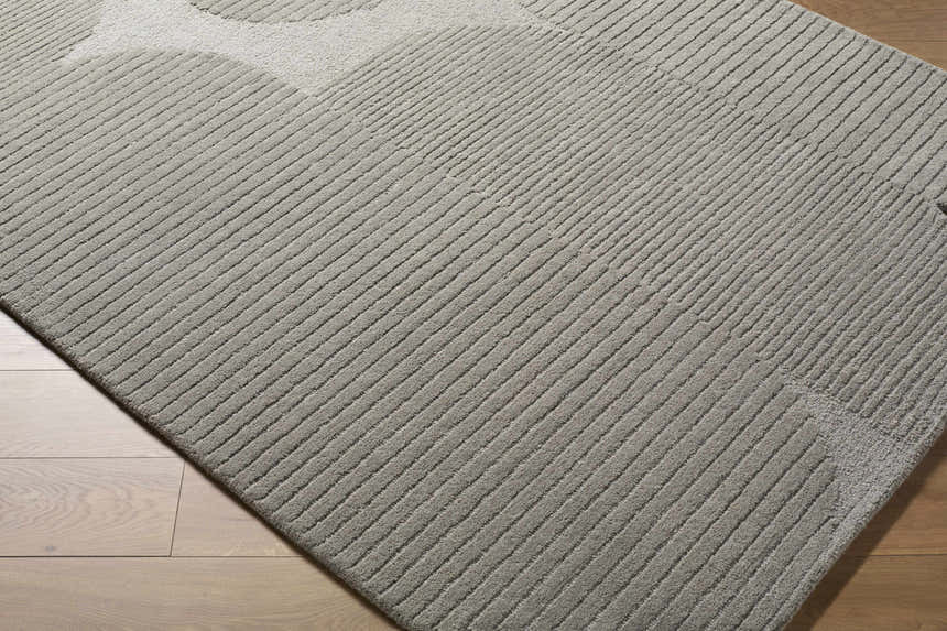Close-up of Fixui Gray Abstract Area Rug. Hand-tufted wool rug with subtle linear pattern and geometric details. Corner