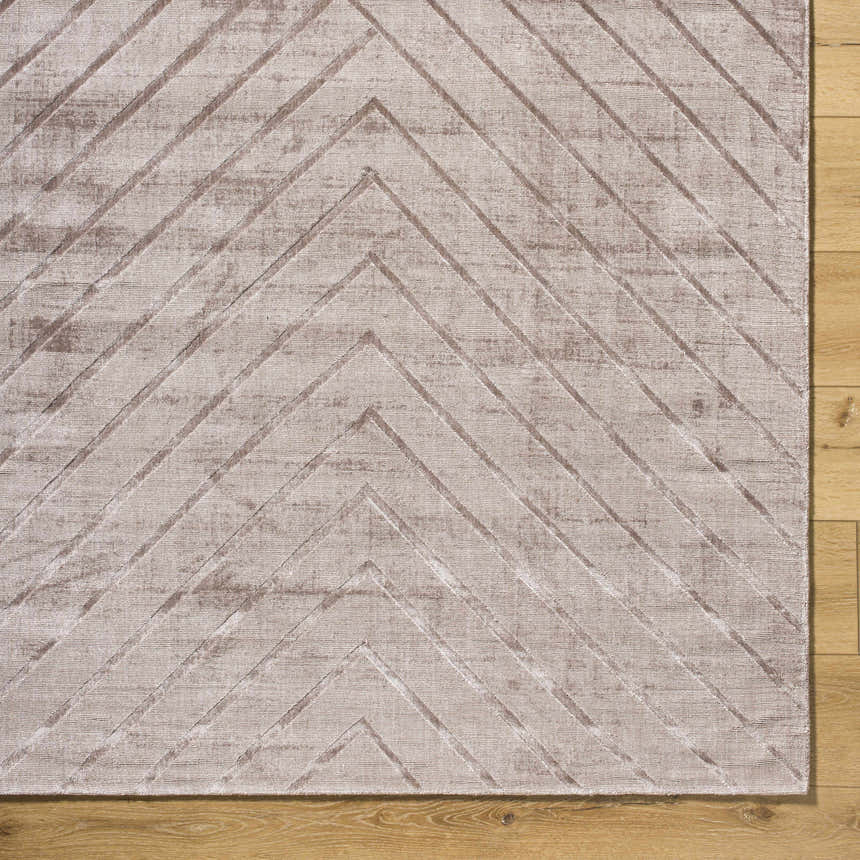 Close-up of Tavran Taupe rug showing subtle linear texture and farmhouse style on hardwood floor. Viscose, hand-loomed rug. Corner