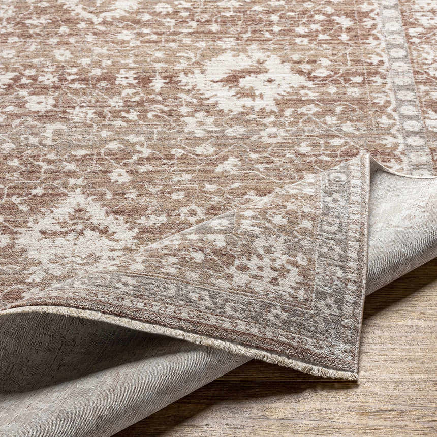 Close-up of the Kaongkod Area Rug showing its dusty pink, ivory, and brown traditional pattern and machine-woven construction. Fold