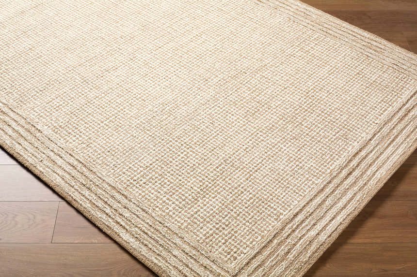 Close up of the hand-tufted Kayoko Beige Area Rug. Neutral colors, subtle diamond pattern, and layered border detail. Corner