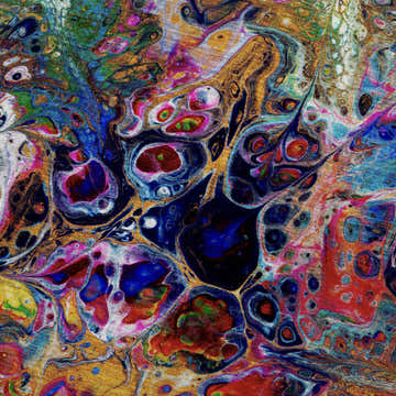 Close-up of Dalyn Kikiamo KK1 Carnival rug. Abstract pattern with carnival, chestnut, gold, green, navy, and purple colors.