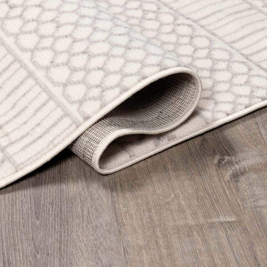 Close-up of the Lascassas Neutral Area Rug showing its geometric pattern, soft texture, and durable machine-woven construction. Fold