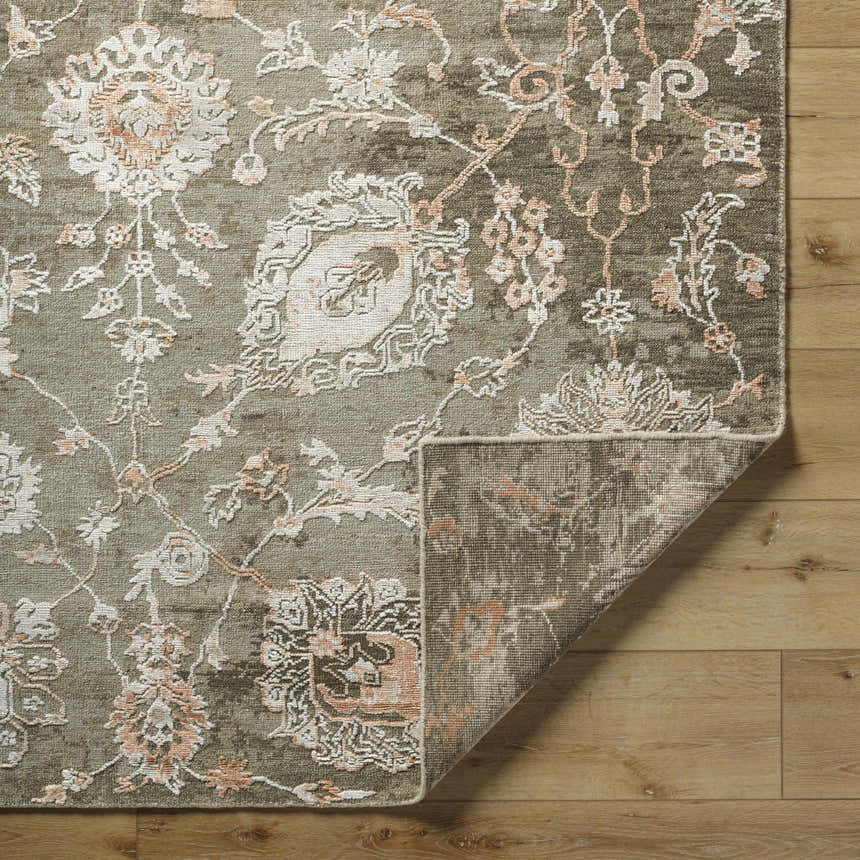 Close up of the Limay Premium Wool Rug showing its taupe, beige, and coral floral pattern. Fold