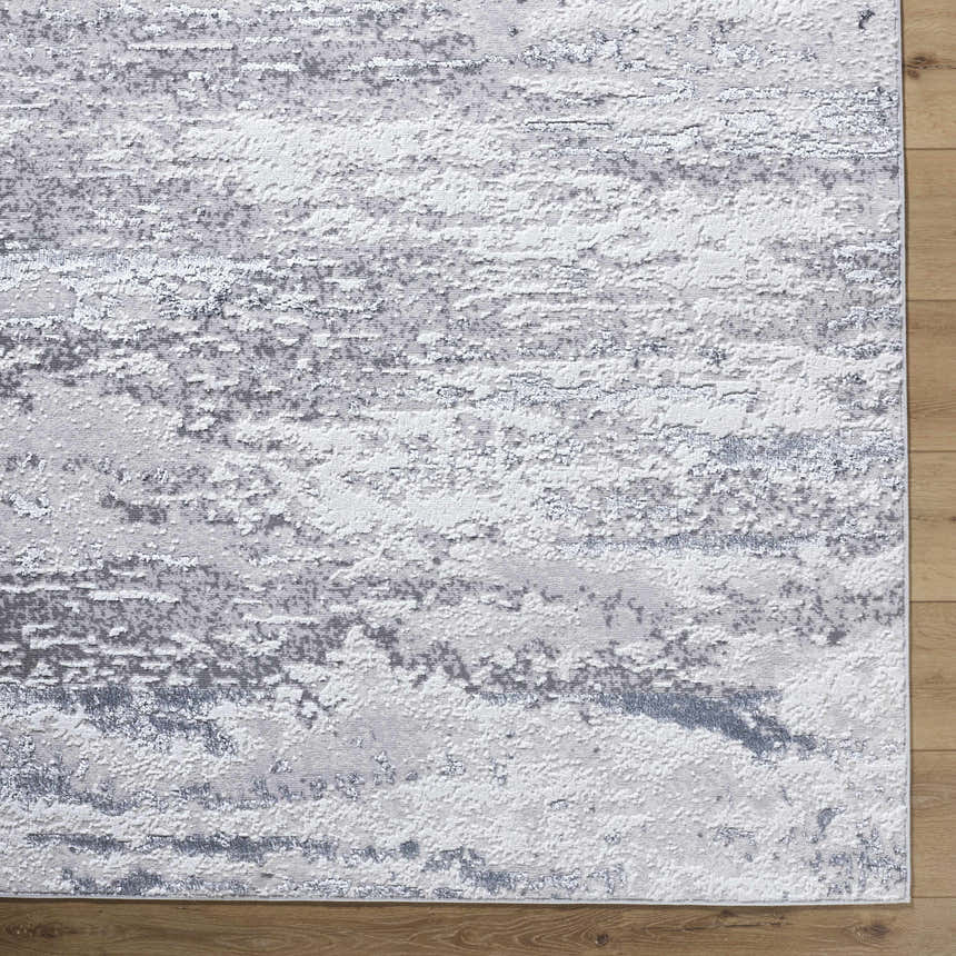 Close-up of the Arenda Light Gray Area Rug showing its contemporary cream, gray, and ivory abstract pattern. Corner