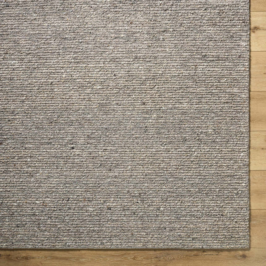 Close-up of the hand-tufted Winta Taupe Wool Area Rug showing its texture and neutral gray, tan, and sage colors. Corner