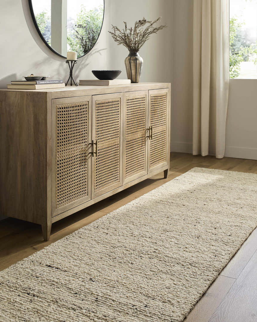 Entryway with a beige Winta Wool Runner Rug, light wood floors, and a rattan cabinet. Roomscene-Runner