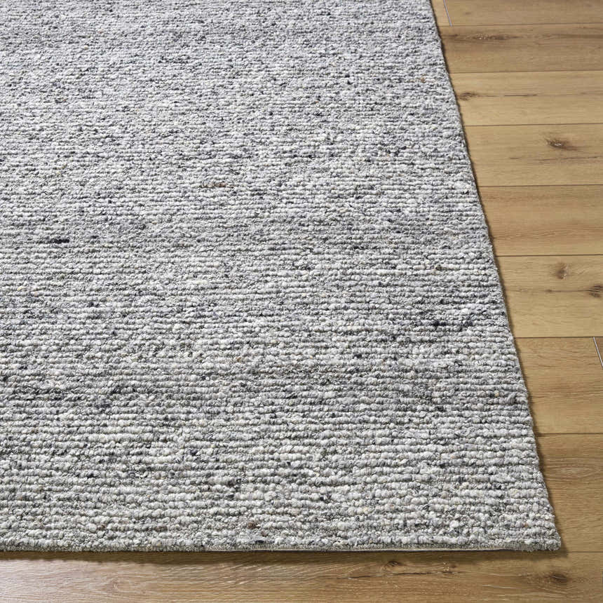 Close-up of the hand-tufted Winta Charcoal Wool Area Rug showing its texture and ash, gray, and silver gray colors. Front