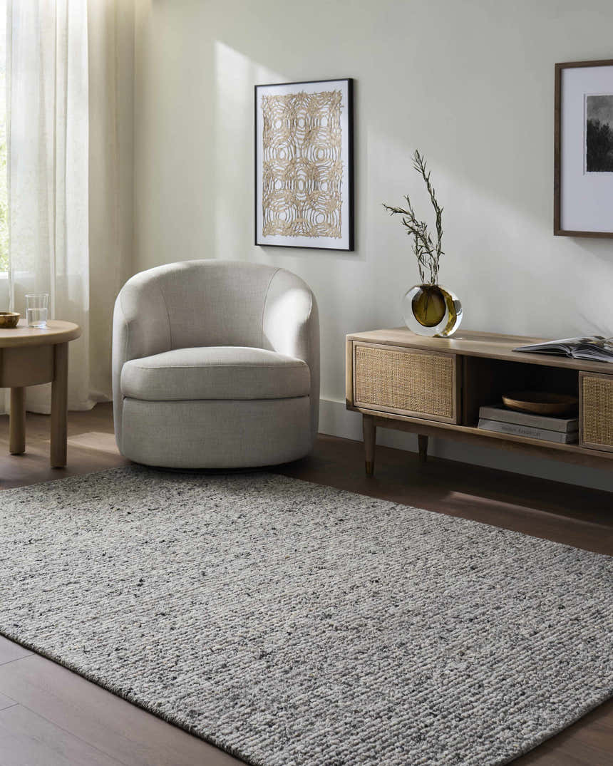 Living room scene with a Winta Charcoal Wool Area Rug, gray chair, and wood media console. Roomscene-Rectangle