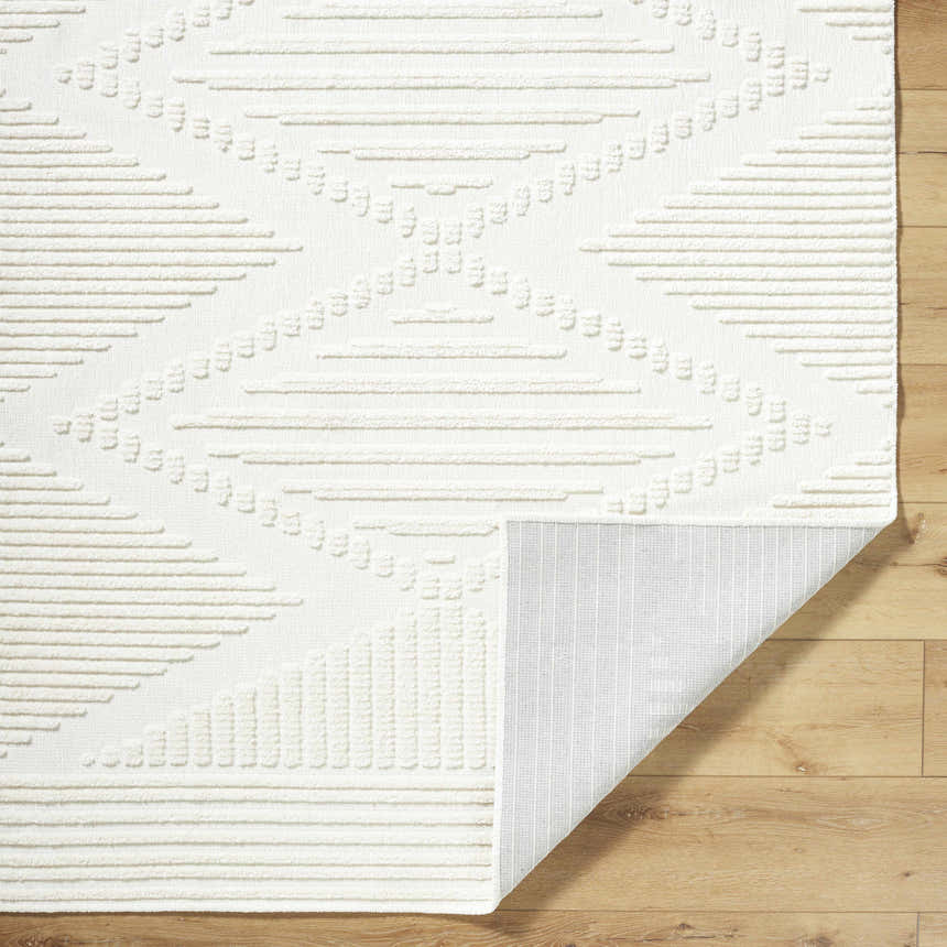 Close-up of the Annika Beige 3D Washable Area Rug showing its geometric pattern and textured design on wood floor. Fold