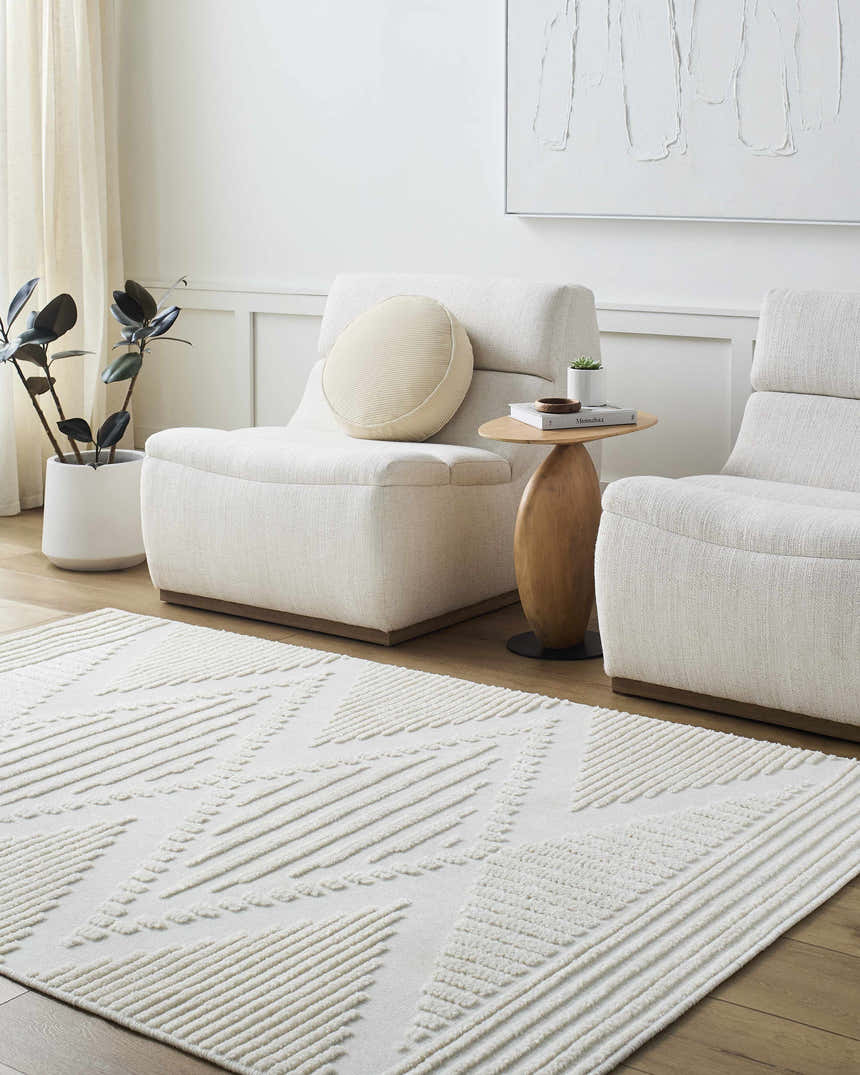 Living room scene with beige Annika 3D Washable Area Rug, off-white chairs, wood side table, and modern decor. Roomscene-Rectangle