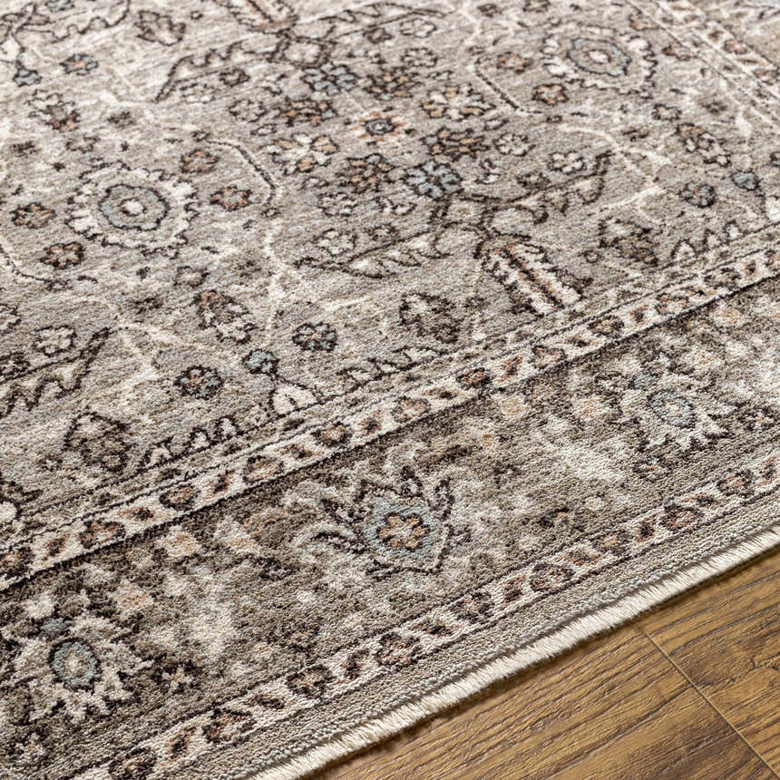 Close-up of the Lugo Luxe Area Rug showing its traditional oriental pattern and tassel detail in charcoal and light gray tones. Texture