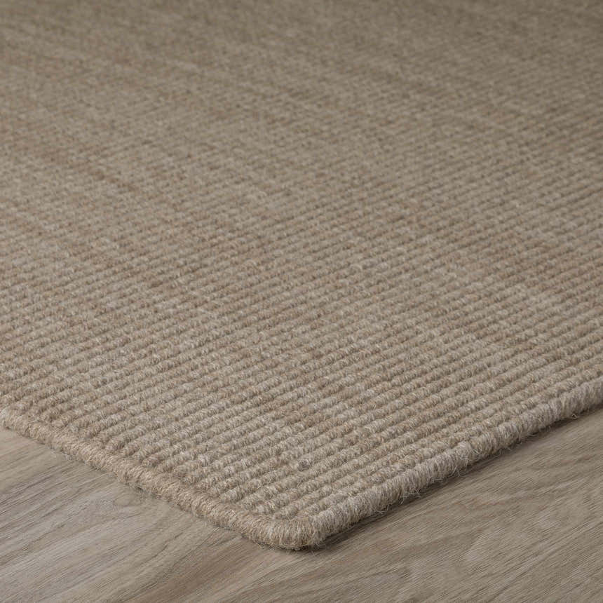 Close-up of the textured, light brown Dalyn Monaco Sisal MC100 Mocha area rug on wood flooring.