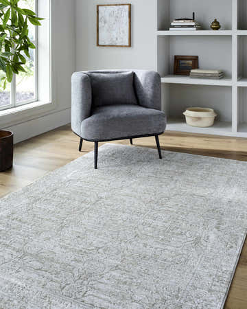 Living room scene with a gray chair on a cream and sage Beth Machine Woven Vivir x LIVABLISS area rug. Roomscene-Rectangle