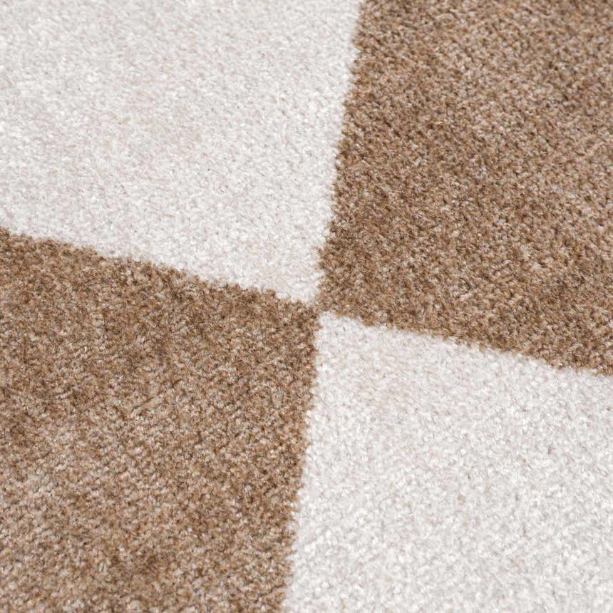 Close-up of the Ulric Brown Diamond Washable Area Rug showing its brown and cream geometric diamond pattern and soft texture. Texture