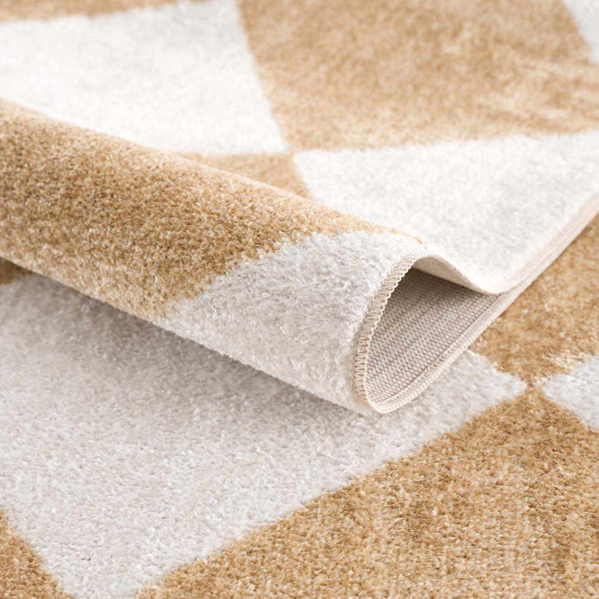 Close up of the Ulric Light Brown Diamond Washable Area Rug showing cream and light brown diamond pattern and soft texture. Fold