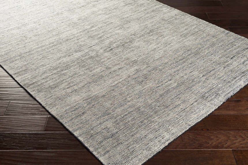 Close-up of the hand-knotted Molena Area Rug. Contemporary style with denim, ink blue, and light olive tones. 90% wool texture. Corner