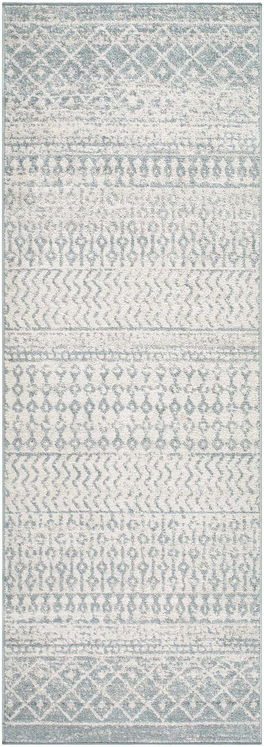 Close-up of the Morey Area Rug. Light gray rug with farmhouse-style geometric patterns and a soft, textured weave. Design-Runner-2776