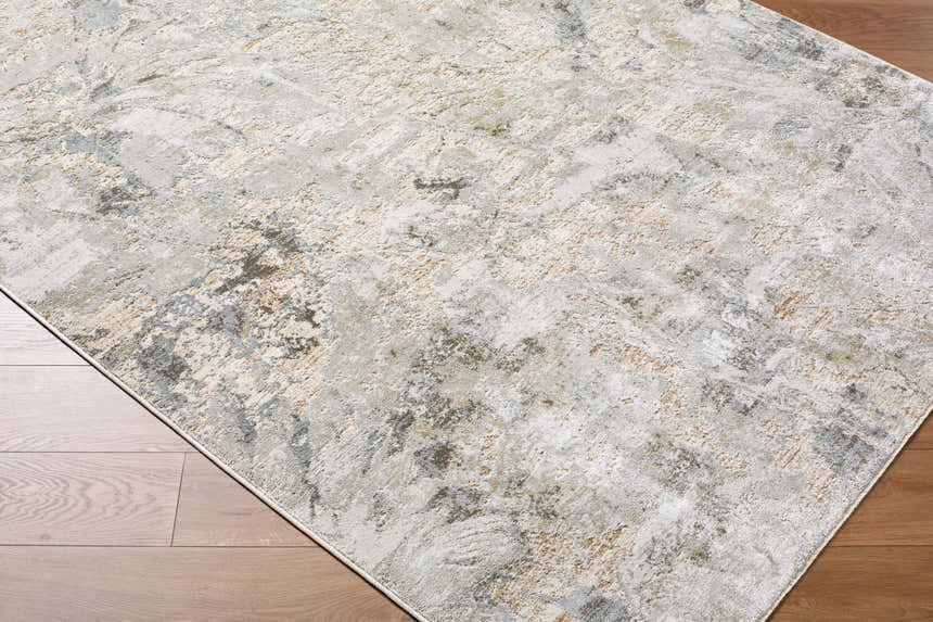 Close-up of the Nurit Sage Thick Luxe Boutique Rug. Abstract design in charcoal, cream, brown, and gray on wood floor. Corner