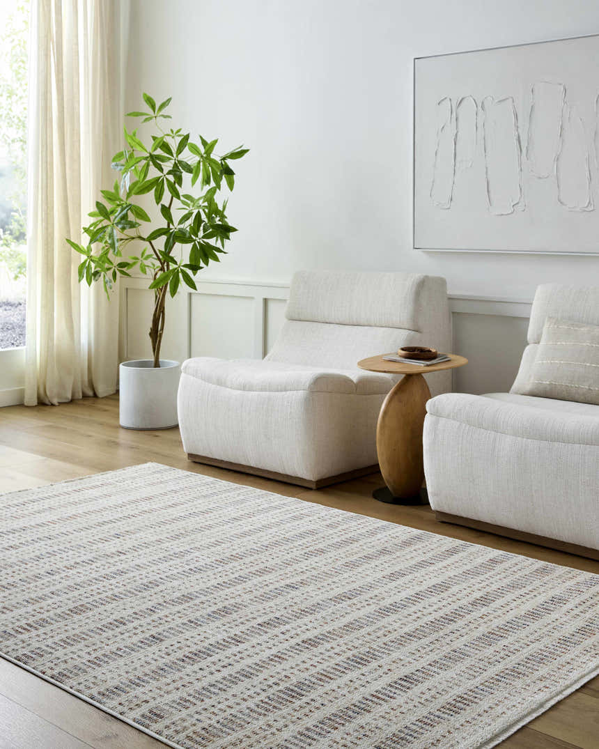 Living room scene with the Nuhad Area Rug, light wood floors, white chairs, side table, and plant. Roomscene-Rectangle