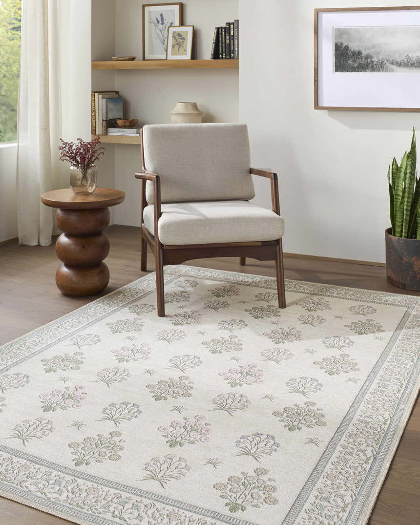 Living room scene with a beige chair on an Aquene Ivory Washable Area Rug with blush, sage, and sky blue floral pattern. Roomscene-Rectangle